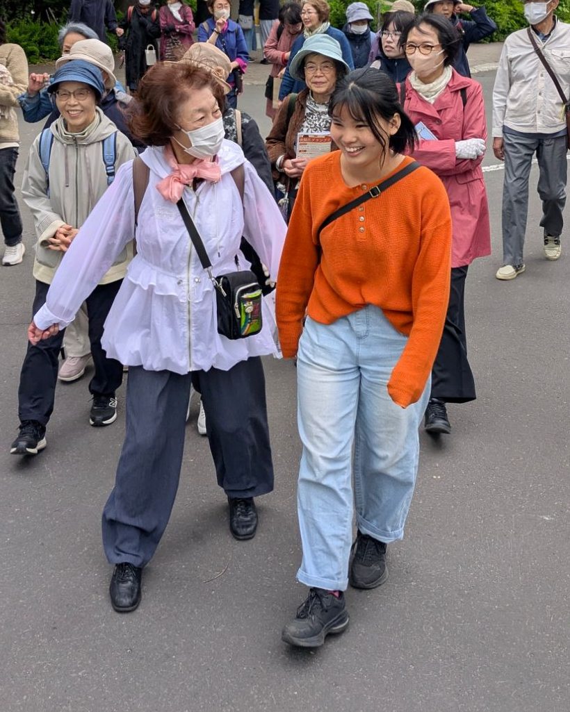 シニアの方と笑顔で並んで歩く代表
